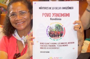 no FOSPA de belém em 2022, uma mulher apresenta um cartaz sobre os martires yanomami